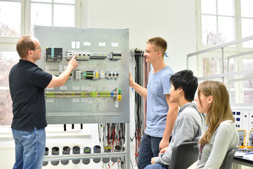Fototapeta Jugendliche und Lehrer in der Berufsausbildung für Elektrotechnik // Vocational Training Electrical Engineering obraz