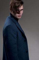Portrait of attractive serious man in a jacket in front of a gray background