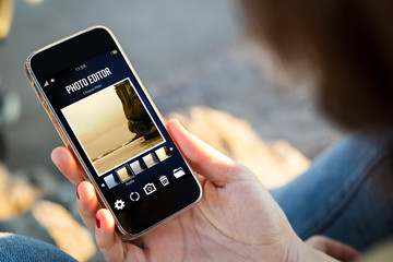 woman sitting in the street holding her smartphone with photo ed