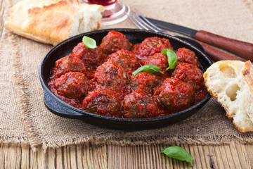 Homemade meatball in frying pan on  rustic wooden table