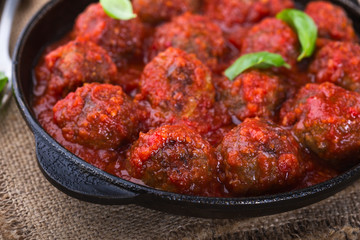 Homemade meatball in frying pan on  rustic wooden table