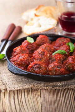 Homemade meatball in frying pan on  rustic wooden table