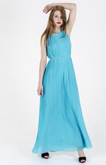 A slender girl with long hair dancing in a long summer dress
