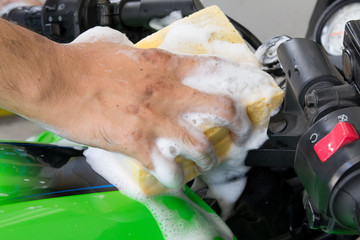 a man washing motorcycle 