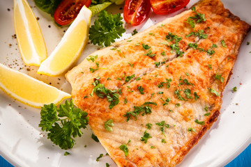 Fish dish - fried fish fillet baked potatoes and vegetables 