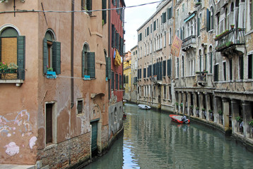 Fototapeta na wymiar VENICE, ITALY - SEPTEMBER 02, 2012: Old typical buildings on narrow channel in Venice, Italy