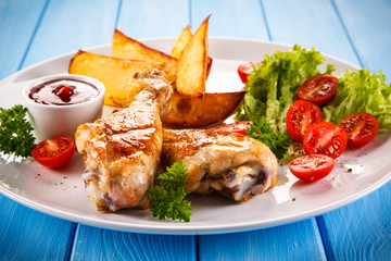 Grilled chicken legs with chips and vegetables 