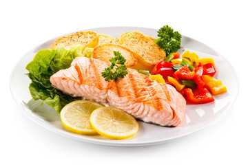 Fried salmon and vegetables on white background 