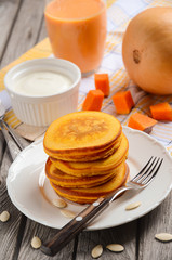 Pumpkin pancakes on white plate with pumpkin smoothie and cream fresh