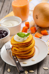 Pumpkin pancakes on white plate with pumpkin smoothie and cream fresh