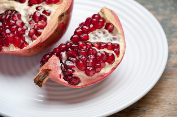 The boy eats a pomegranate