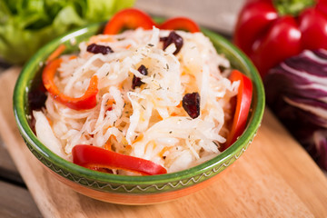 Sour cabbage with cranberries on the vegetables background
