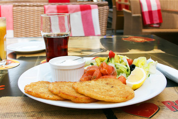 Potato pancakes with salmon and salad