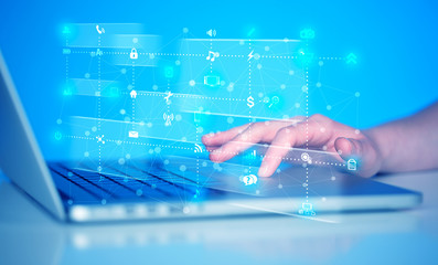 Hand pressing keyboard with high tech media icons