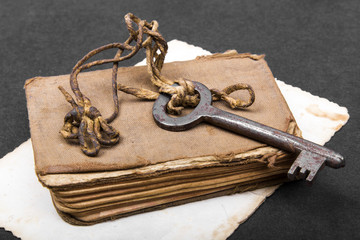 Rusty key, old book and empty photography as a knowledge metaphor