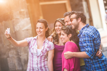 Group of tourists or friends taking a selfie in Pisa, Italy,  They are two men and three women. Lifestyle, friendship and travel concepts.
