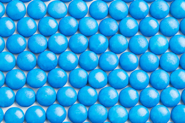 Close up neatly arranged blue milk chocolate candies crisp shell