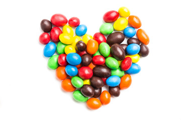 Fototapeta na wymiar Heart shape with colorful milk chocolate candies on white backgr