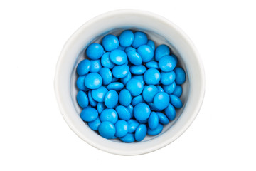Overhead view bowl of blue chocolate candy in white background
