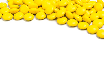 Top right frame of yellow chocolate candy on white background