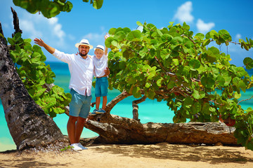 smiling father and son on summer vacation near the tropical seaside