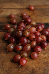 Red gooseberry on wooden table close-up