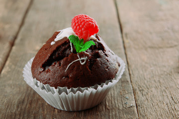 Delicious chocolate cupcake on wooden table close up