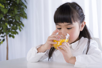 オレンジジュースを飲む女の子