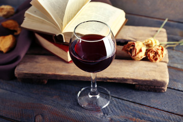 Beautiful composition with glass of wine with old books on table close up