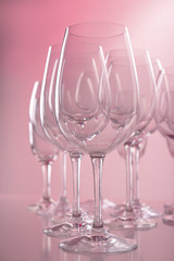 Empty wine glasses on color background
