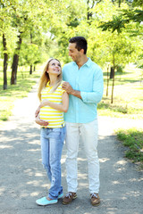 Young pregnant woman with husband in park