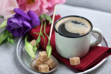 Cup of coffee with flowers on tray, closeup