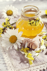 Obraz na płótnie Canvas Honey and flowers on napkin closeup