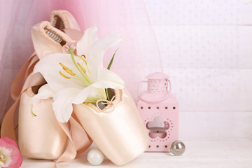 Decorated with flowers ballet shoes on rosy satin background