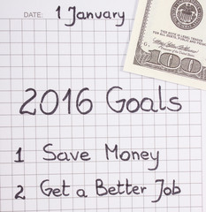New years resolutions written in notebook and currencies dollar