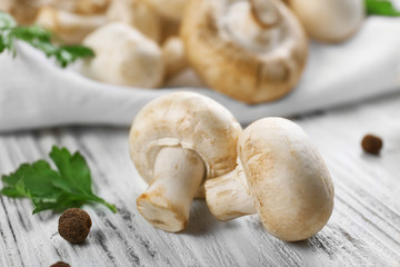 Champignon mushrooms and spices on white wooden background