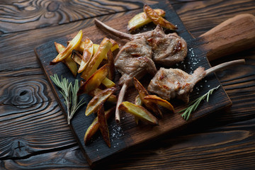 Rustic wooden chopping board with grilled bobby veal rack steaks