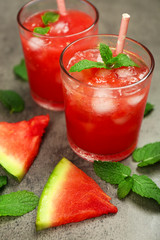 Cold watermelon drinks in glasses, on dark background