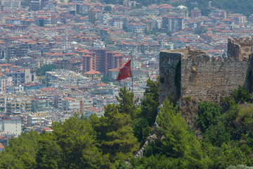 Turkish flag on the background of houses of the central district of Alanya. View from the ancient fortress of Alanya.