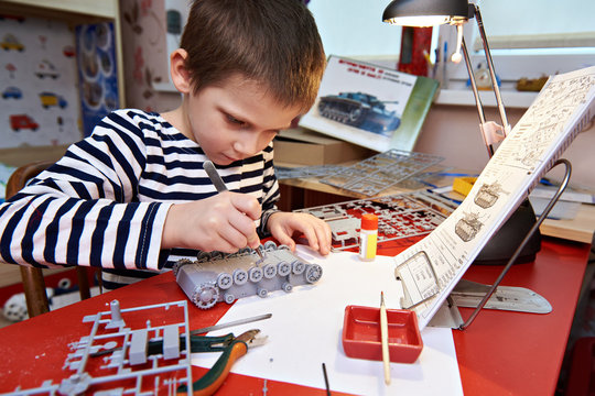 Little boy collects plastic model tank