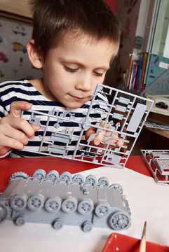 Little boy collects plastic model tank