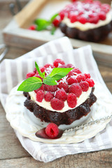 Sweet cakes with raspberries on wooden table background