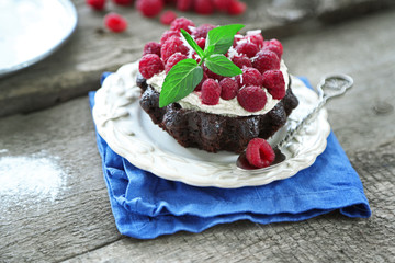 Sweet cakes with raspberries on wooden table background