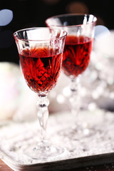Wine glasses with Christmas decorations on snowy table, close up