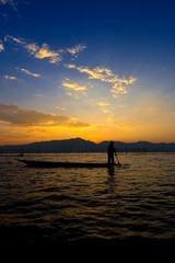 Silhouettes of the traditional fishermen throwing fishing net du