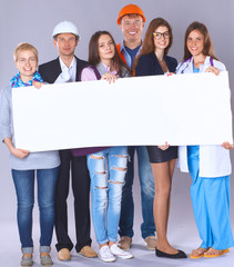 Portrait of smiling people with various occupations holding blank billboard