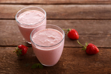 Fresh strawberry yogurt with berries around on wooden background