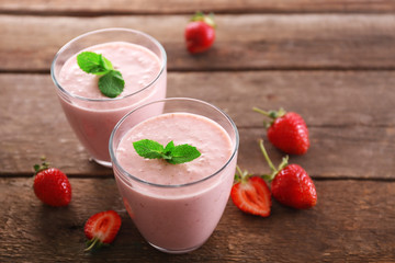 Fresh strawberry yogurt with berries around on wooden background