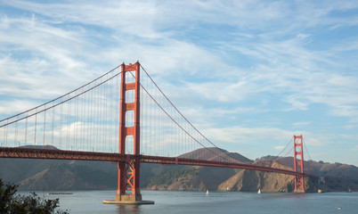 Fototapeta na wymiar The Golden Gate Bridge with Wispy Clouds. Taken from Battery E Trail near the Golden Gate Bridge Welcome Center.