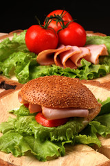 Sandwich and tomatoes on wooden desk